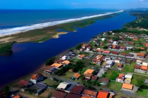 Vista aérea de Barra Velha SC, cidade do litoral norte com lagoa, praia extensa e casas de baixo gabarito, ideal para quem pensa em morar em Barra Velha